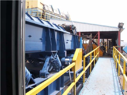 Industrial vibratory conveyor from Action Vibratory Conveyors handling bulk material flow during slow conveyance troubleshooting.